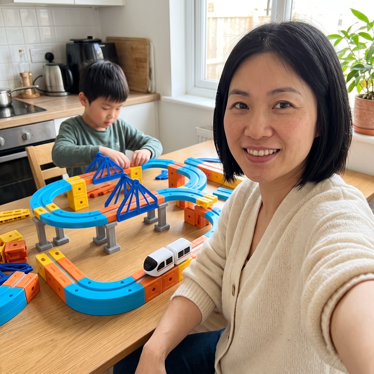 Parent taking a selfie beside a child building a railway